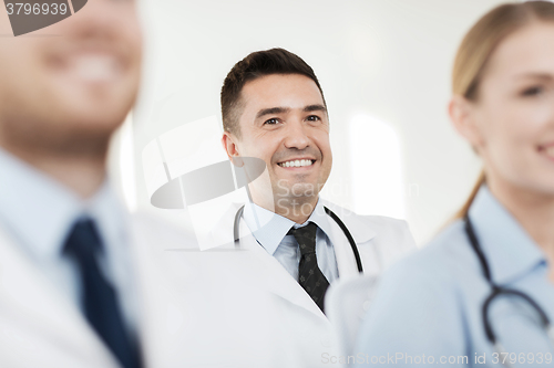 Image of happy doctor over group of medics at hospital