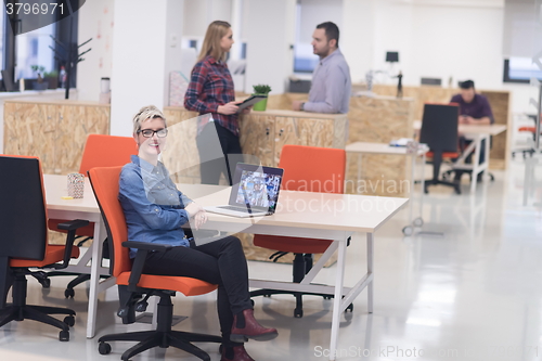 Image of portrait of young business woman at office with team in backgrou