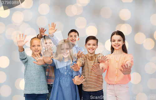 Image of happy children waving hands over holidays lights