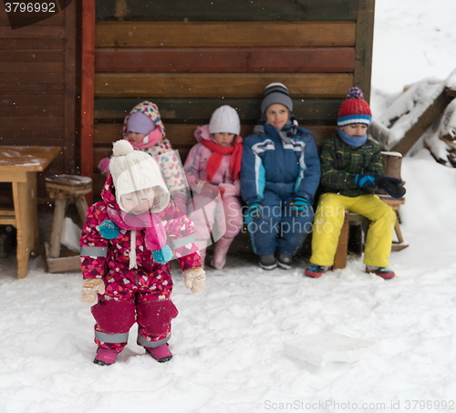 Image of little children group sitting  together  in front of wooden cabi