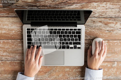 Image of close up of female hands with laptop and mouse