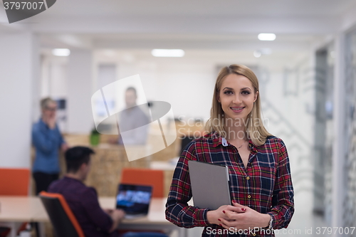 Image of portrait of young business woman at office with team in backgrou