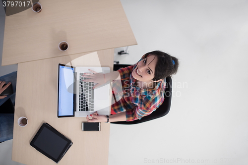 Image of top view of young business woman working on laptop