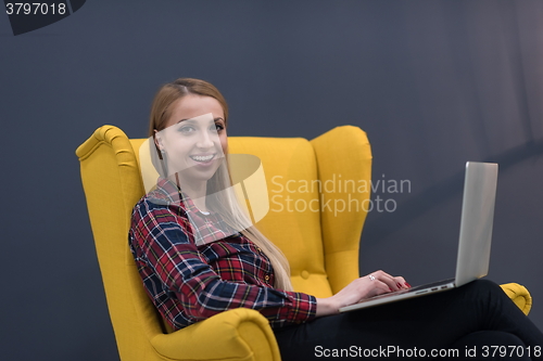 Image of startup business, woman  working on laptop and sitting on yellow