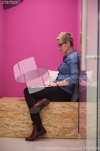 Image of woman in crative box working on laptop