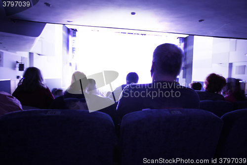 Image of People watching at bright screen in cinema