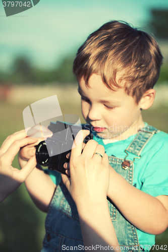 Image of Mother helping her son to make his first photos