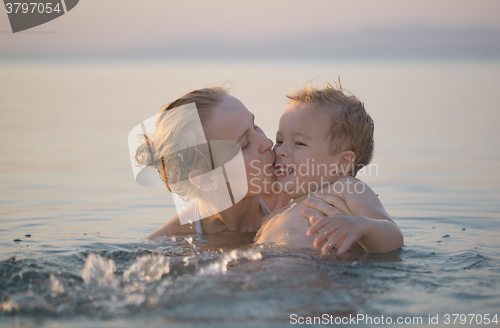 Image of Mother playing in the sea with her little son