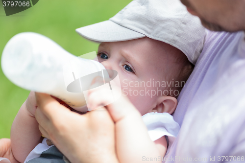 Image of Man bottle feeding baby