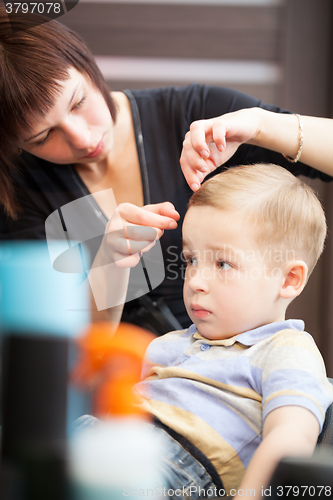 Image of Hairdresser finishing boys haircut with hair setting