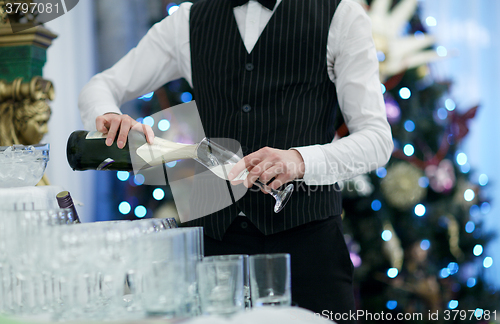 Image of Waiter pouring glasses of champagne