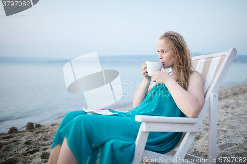 Image of Woman enjoying a cup of tea at the seaside