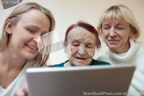 Image of Three women using a smart tablet