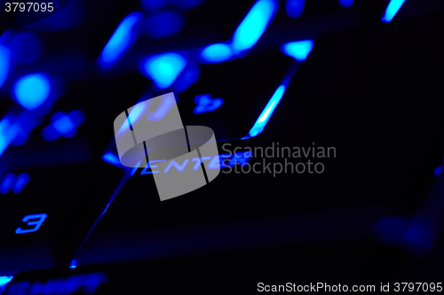 Image of Enter key in a blue light. Macro shot.