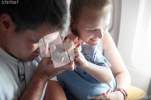 Image of Parents and child listening something on the cell