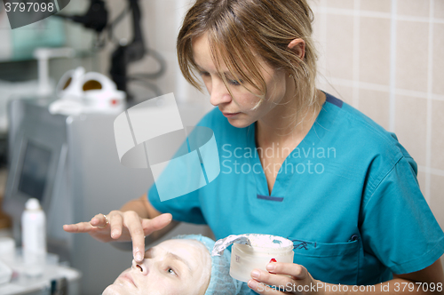 Image of Nurse in a skin clinic applying protective cream