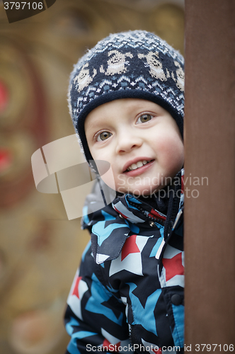 Image of Cute little boy peering around a door