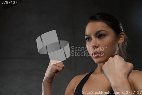 Image of woman holding fists and fighting in gym