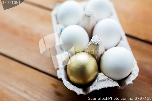 Image of close up of white and gold eggs in egg box