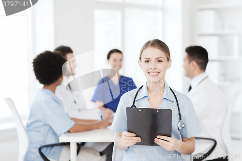 Image of happy doctor over group of medics at hospital