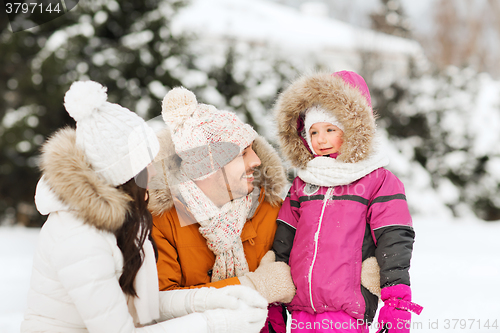 Image of happy family with child in winter clothes outdoors