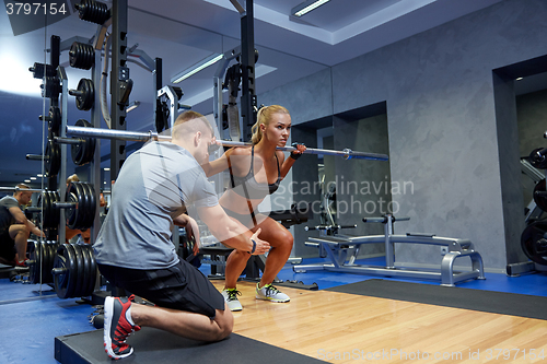 Image of man and woman with bar flexing muscles in gym