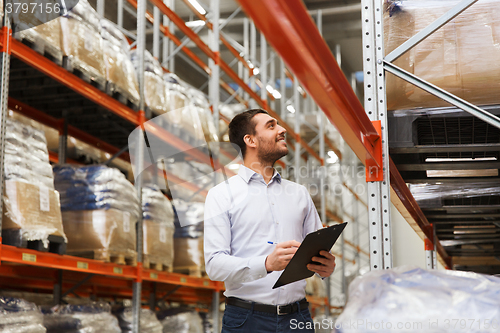 Image of businessman with clipboard at warehouse