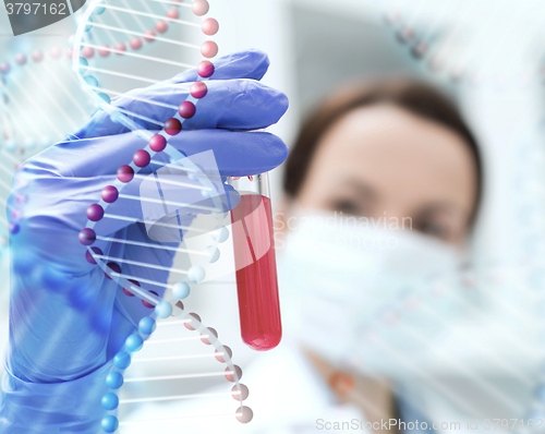 Image of close up of scientist holding test tube in lab