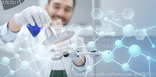 Image of close up of scientist with test tubes and funnel