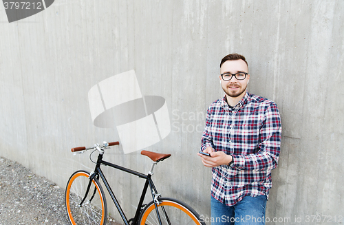 Image of hipster man in earphones with smartphone and bike