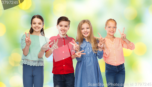 Image of happy boy and girls showing peace hand sign