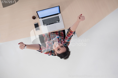 Image of top view of young business woman working on laptop
