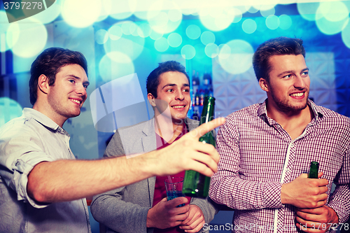 Image of group of male friends with beer in nightclub