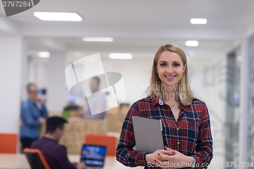 Image of portrait of young business woman at office with team in backgrou