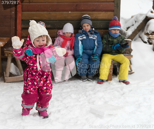 Image of little children group sitting  together  in front of wooden cabi