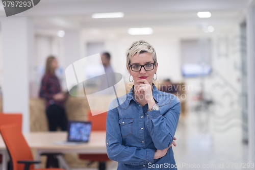 Image of portrait of young business woman at office with team in backgrou