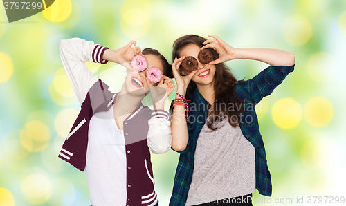 Image of happy pretty teenage girls with donuts having fun