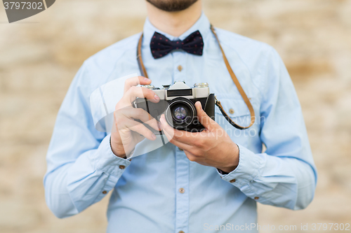 Image of close up of hipster man with film camera in city