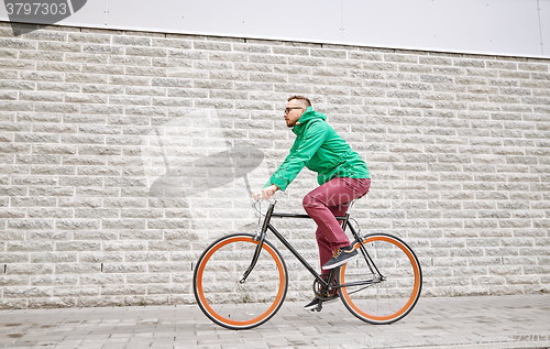 Image of young hipster man riding fixed gear bike