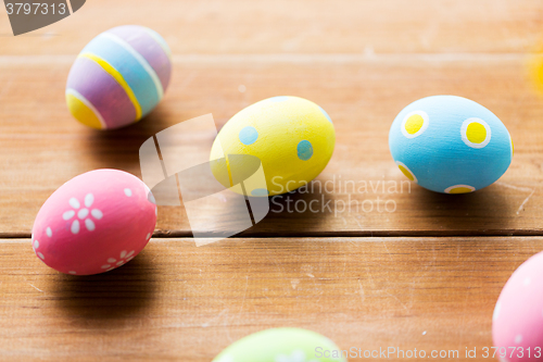 Image of close up of colored easter eggs on wooden surface