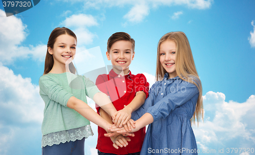 Image of happy children with hands on top over blue sky