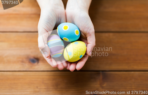 Image of close up of woman hands with colored easter eggs