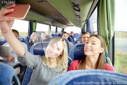 Image of women taking selfie by smartphone in travel bus