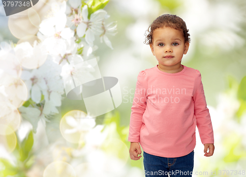 Image of beautiful little baby girl over cherry blossoms
