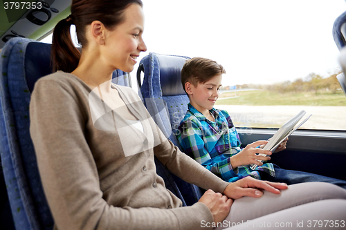 Image of happy family with tablet pc sitting in travel bus