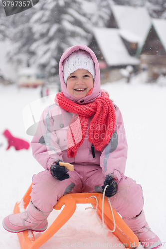 Image of little girl sitting on sledges