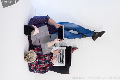 Image of top view of  couple working on laptop computer at startup office