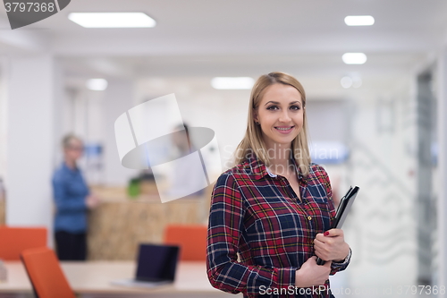 Image of portrait of young business woman at office with team in backgrou