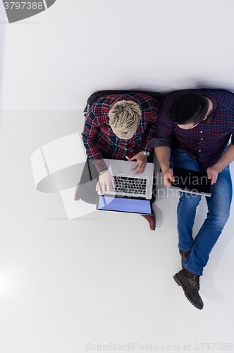 Image of top view of  couple working on laptop computer at startup office