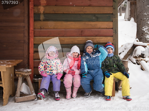 Image of little children group sitting  together  in front of wooden cabi